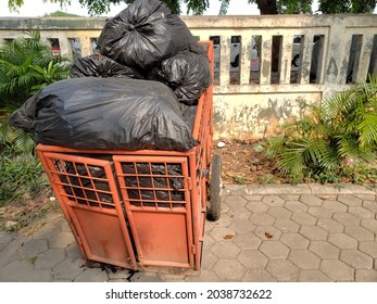 Orange Garbage Cart Filled With Garbage In The Yard