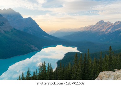 The orange glow of sunset over Peyto Lake in Banff National Park with a green forest - Powered by Shutterstock