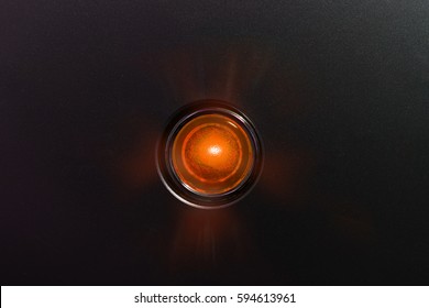 Orange Glowing Status Indicator, Warning Lamp Or Button, On Black Panel.