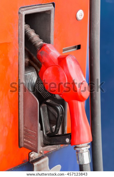 Orange hoses of\
petrol pump in a gas\
station
