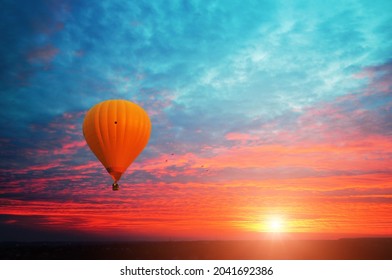 Orange hot air balloon with a basket in a sky with a bright sunset - Powered by Shutterstock