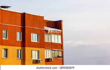 Orange House, High Floor Against A Blue Frosty Day. Icicles On The Roof