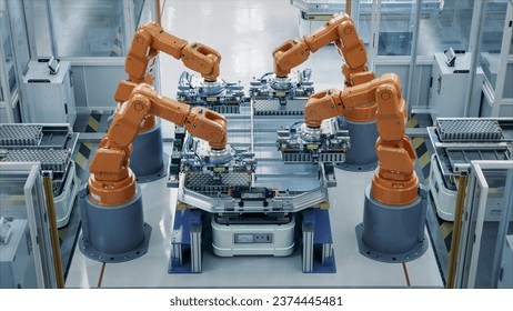 Orange Industrial Robot Arms Assemble Skateboard style EV Battery Pack on Automated Production Line. Electric Car Smart Factory Equipped with Robotic Arms. Top View. Automotive Battery Manufacturing. - Powered by Shutterstock