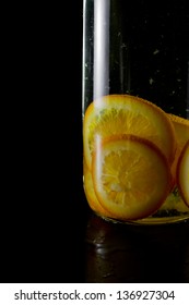 Orange Infused Vodka Bottle On A Dark Black Background