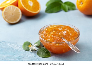 orange jam in a glass jar, orange pieces on a blue background - Shutterstock ID 2206543061
