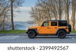 Orange Jeep Wrangler, framed by the majestic beauty of the Blue Ridge Mountains: A perfect blend of rugged exploration and scenic vistas, capturing the spirit of outdoor freedom.