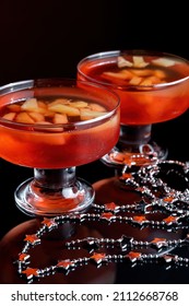 Orange Jello On A Beautiful Bowl With Fruit Pieces Inside. Black Background.