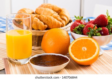 orange juice, croissants and strawberries still life