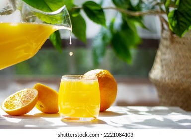 Orange juice drops pouring from pitcher into glass. Healthy citrus drink. Summer freshness concept. - Powered by Shutterstock