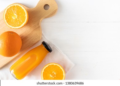 Orange Juice In A Glass Bottle With Sliced Fruit On White Wooden Background, Top View And Flay Lay Of Natural Source Of Vitamin C