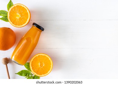 Orange Juice In A Glass Bottle With Sliced Fruit On White Wooden Background, Top View And Flay Lay Of Natural Source Of Vitamin C