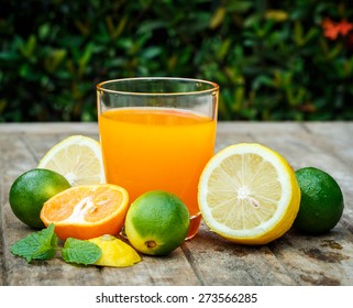 Orange Juice With Lemon, Lime And Mint On A Wooden Board