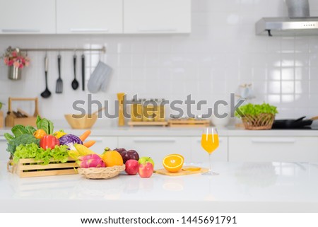 Orange juice is placed on a white table, orange juice, bright colors placed on the table and the atmosphere in the kitchen is clean white.