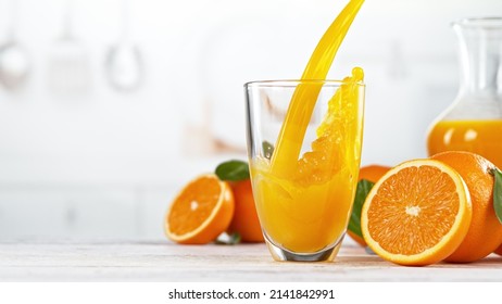 Orange juice pouring into glass. Fresh orange juice with oranges fruit in kitchen. Free space for text. Healthy nad diet concept. - Powered by Shutterstock