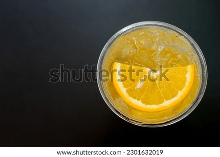 orange juice with soda on the black table.
