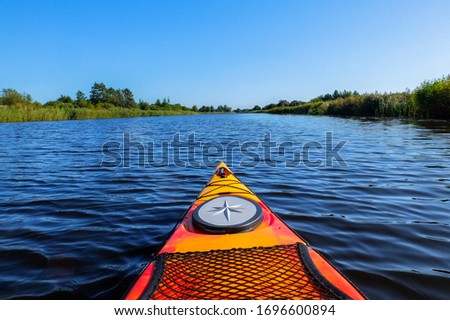 Orange kayak on a river Daugava in Latvia