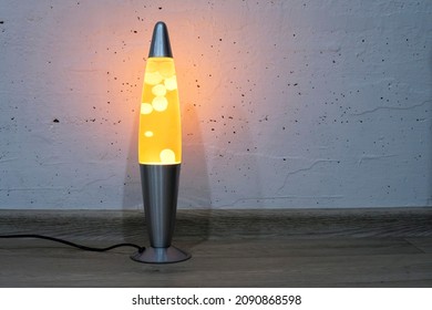 Orange Lava Lamp Stands Near A White Wall