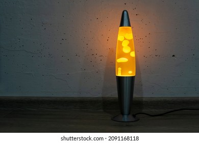 Orange Lava Lamp Stands Near A White Wall