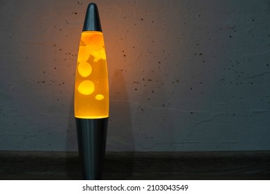 Orange Lava Lamp Stands Near White Wall