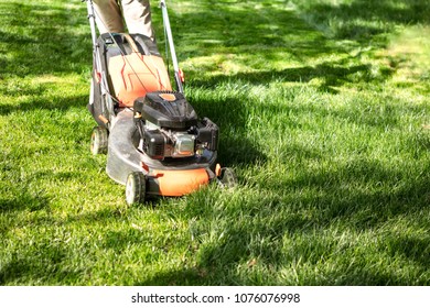 Orange  Lawn mower cutting grass. Gardening concept background - Shutterstock ID 1076076998