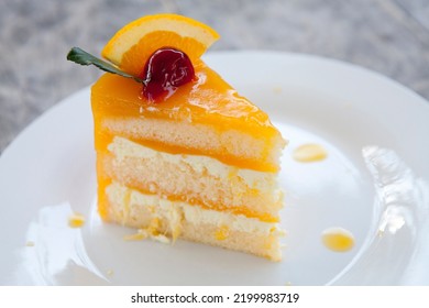 Orange Layer Cake On Top With A Red Cherry