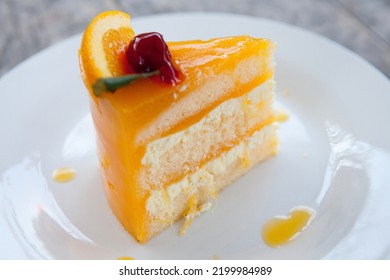 Orange Layer Cake On Top With A Red Cherry