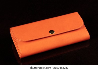 Orange Leather Wallet On A Dark Background.