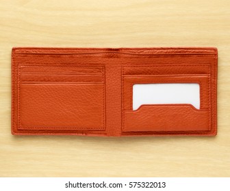 Orange Leather Wallet On Wooden Board Background