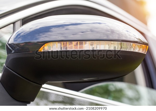 Orange LED turn signal in the mirror of a\
modern car, close-up.\
Transportation