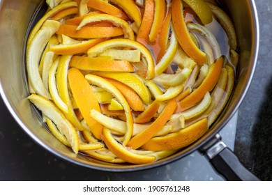 Orange and lemon peels slices and placed in a pan of boiling wather and sugar to make candied peels