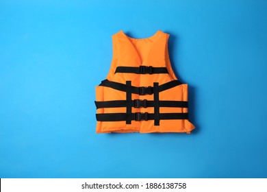 Orange life jacket on blue background. Personal flotation device - Shutterstock ID 1886138758