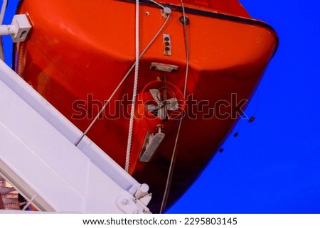 an orange lifeboat still hanging