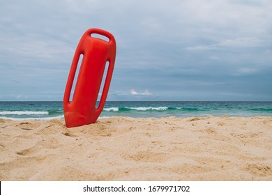 orange lifebuoy buried on the beach