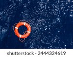 Orange lifebuoy floating on the surface of the ocean, needed help for those who fall overboard. 