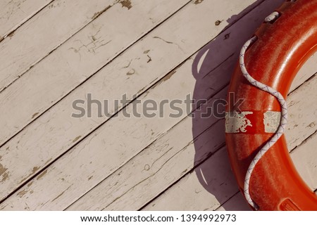 orange lifebuoy on wooden background. Life buoy hanging on wooden wall for emergency response when people sinking to water almost place near pool and beach. vintage photo processing