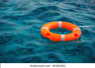 Orange Lifebuoy in a stormy blue sea - Powered by Shutterstock