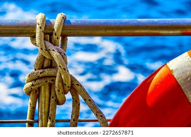 Orange lifeline and sea ropes on the background of the sea and blue sky. Sea ropes. Close up. Sea - Powered by Shutterstock