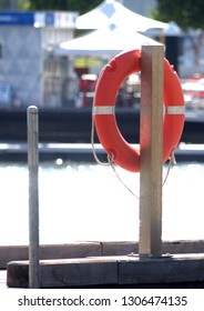 Orange Lifesaver Buoyancy Aid Next To A Water Dock 