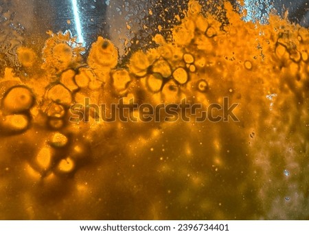 Orange light and soap bubbles on a windshield similar to a lava lamp appearance