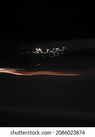 Orange Light Trail With White Curly Light Trail Background In The Dark Of The Night