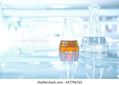 Orange Liquid And Water In Flask On Science Table Laboratory  