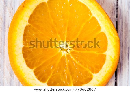 Orange in macro. Cut an orange into a slice.