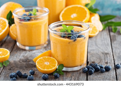 Orange And Mango Healthy Smoothie Served With Granola And Berries