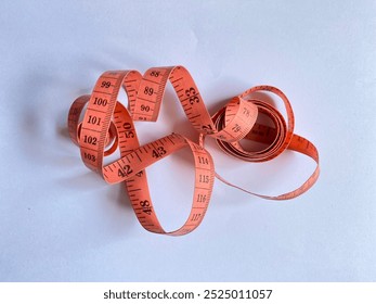 Orange measuring tape. Close up measuring tape. Red tape measure spiral creates a visual impression of 
motion. on white background. measuring tape isolated.  - Powered by Shutterstock