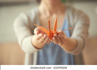 Orange Origami Crane In Hands Of Woman