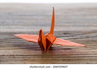 Orange Origami Paper Crane On Wooden Table.