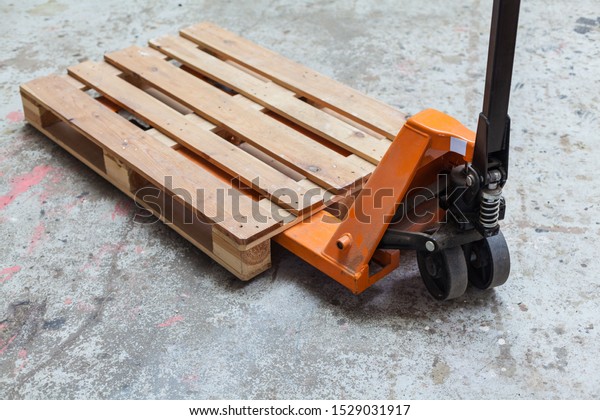 Orange pallet truck, pallet truck with\
empty pallet, pallet jack transport warehouse\
storage