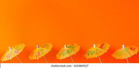 Orange Paper Cocktail Umbrellas On Vivid Background. 