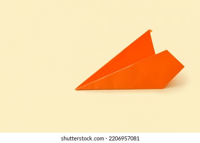 Orange Paper Plane On Beige Background