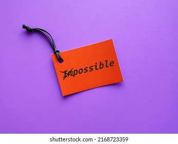 Orange Paper Tag On Purple Background With Text IMPOSSIBLE Crossed Off To POSSIBLE, Crossed Off To POSSIBLE, Keeping In Mind To Make The Impossible Possible, Focus On All The Ways To Accomplish Goals